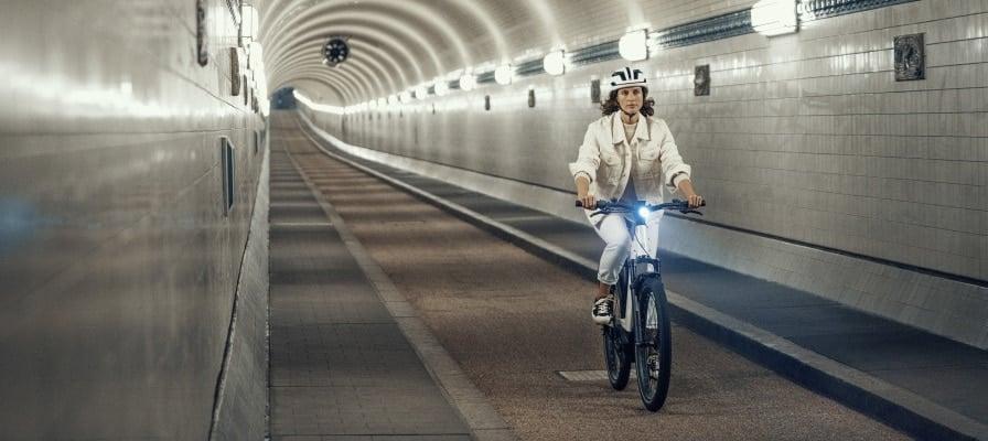 Person fährt Riese & Müller Nevo3 E-Bike durch beleuchteten Tunnel