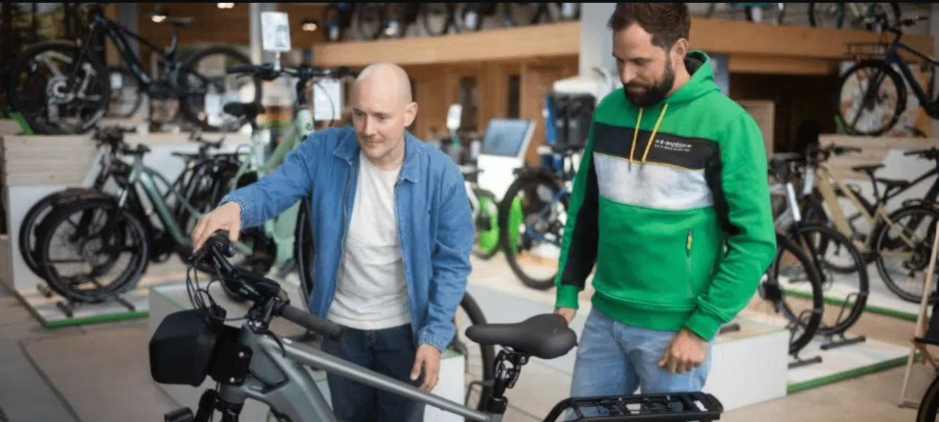 Zwei Männer betrachten ein E-Bike in einem Fahrradgeschäft