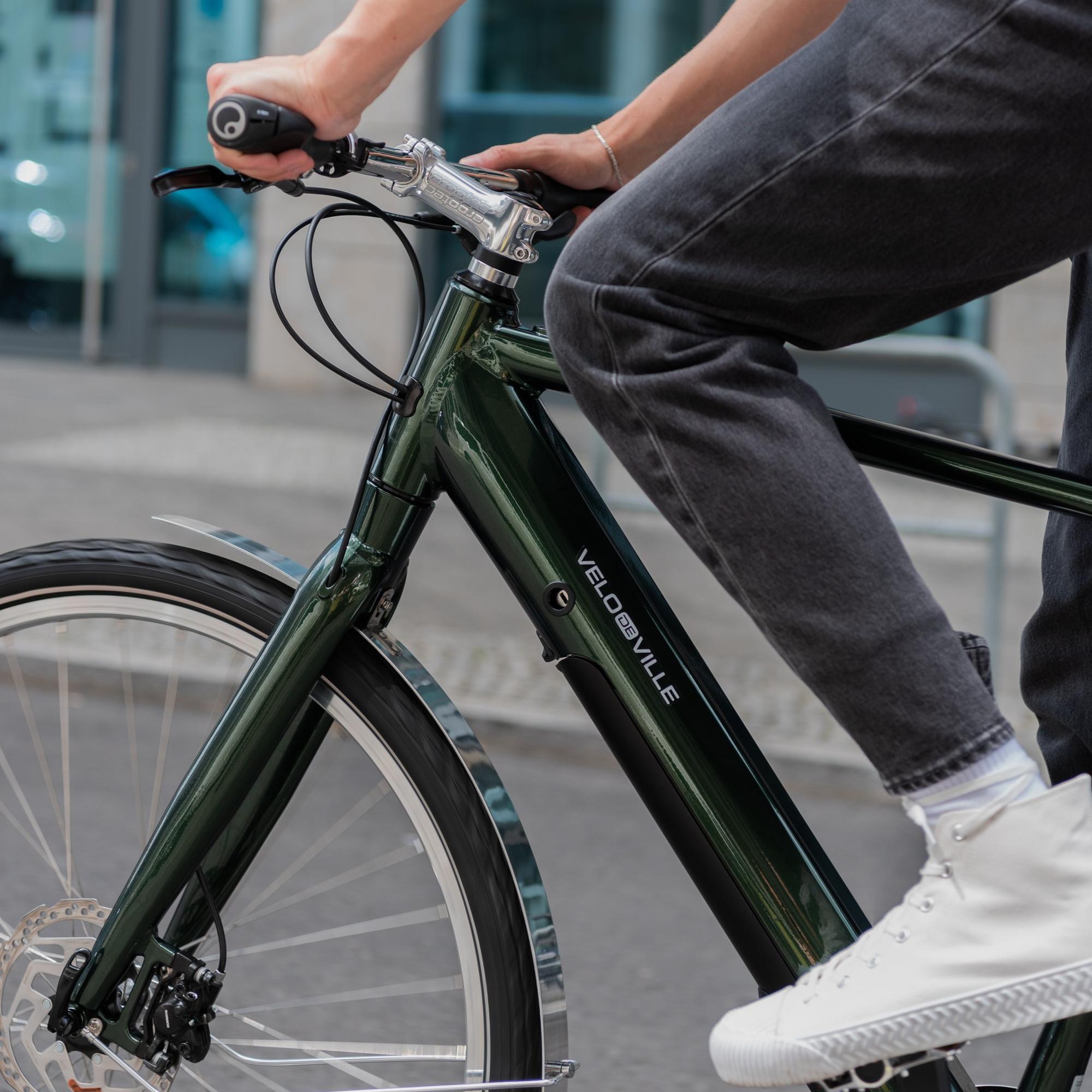 Eine Detailansicht einer Person auf dem Velo de Ville e-Bike
