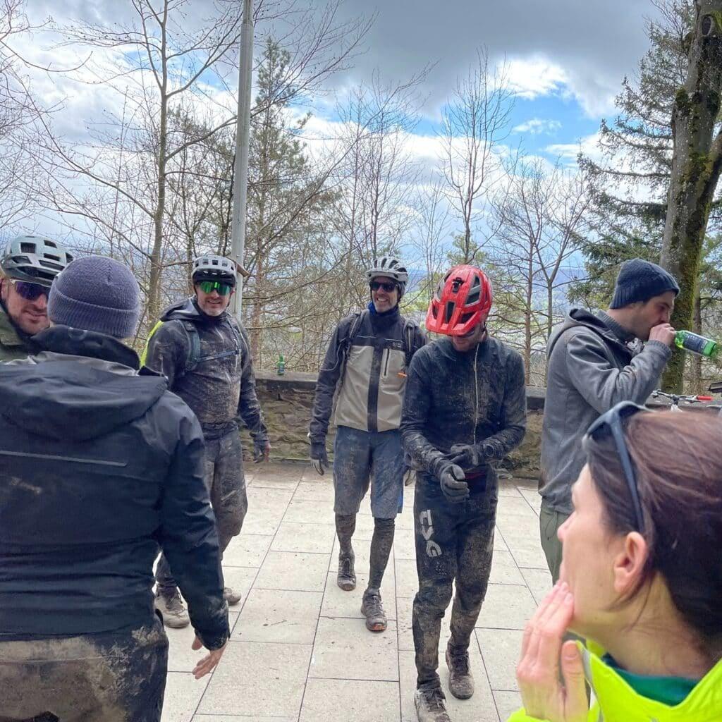 Gruppe von Mountainbikern in schlammiger Ausrüstung im Freien