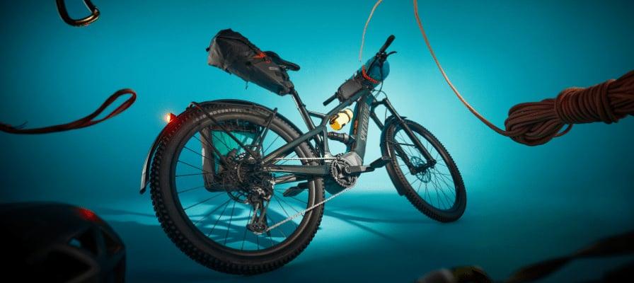 E-Mountainbike mit Zubehör vor blauem Hintergrund