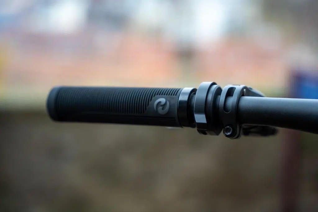 Nahaufnahme eines Fahrradlenkers mit Gummigriff und Logo