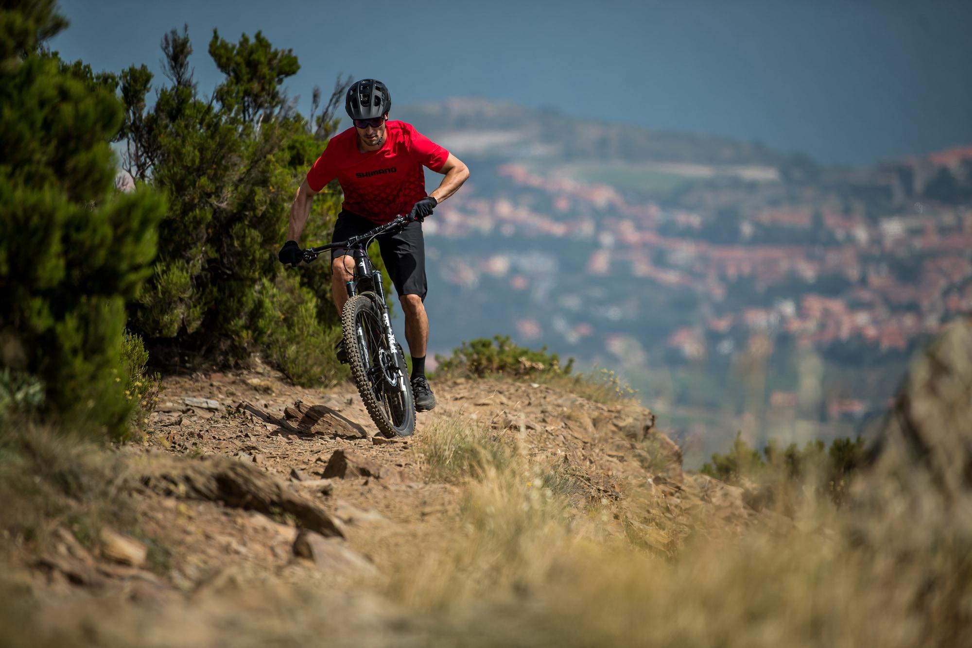 Erleben Sie das Abenteuer mit einem Mountainbiker, der einen steinigen Pfad herunterfährt, unterstützt vom Shimano
