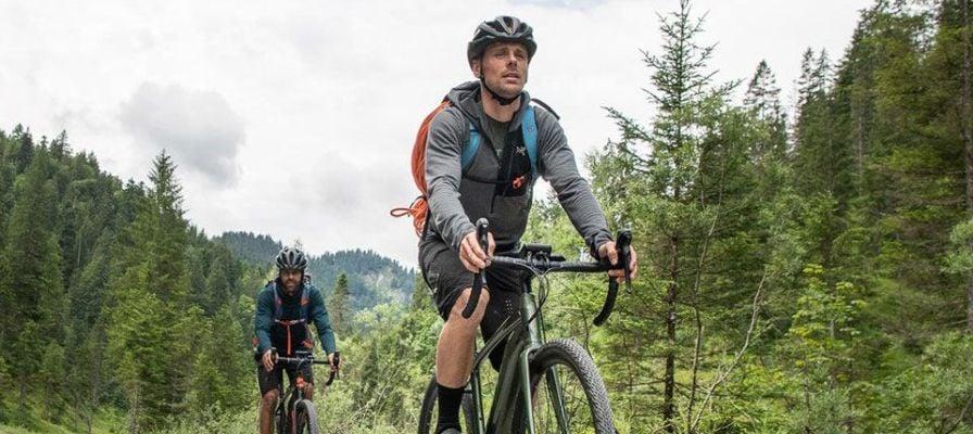 Zwei Personen auf Gravel-E-Bikes in waldreicher Umgebung