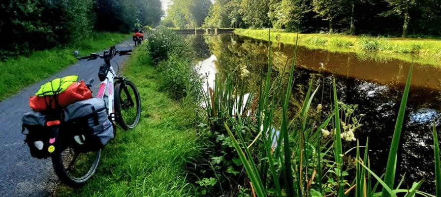 Fahrrad mit Gepäcktaschen auf Waldweg entlang eines Kanals in Dietikon