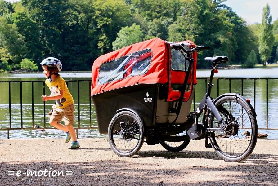 Lasten-E-Bike von Riese & Müller vor einem See mit spielendem Kind
