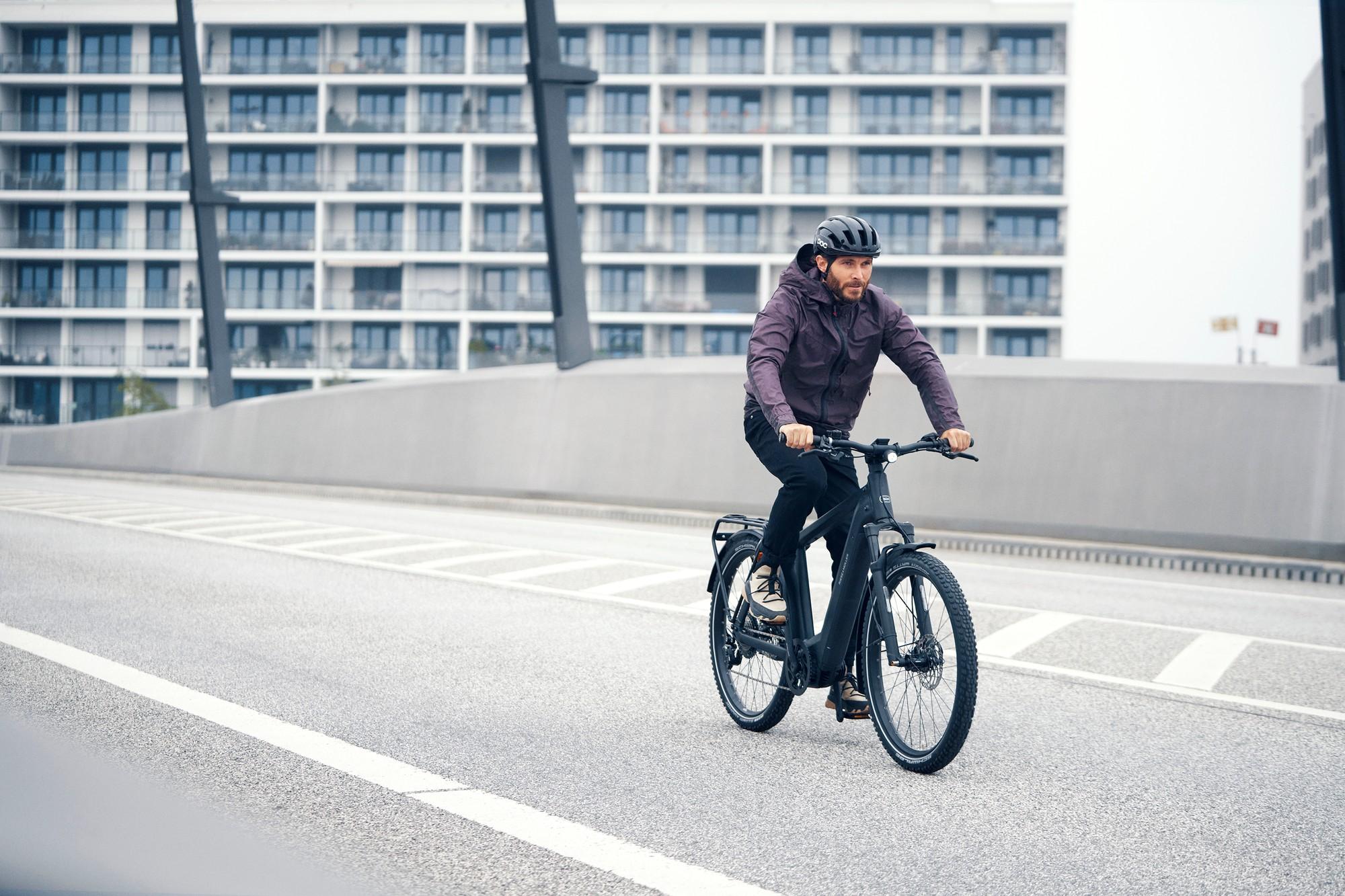 Ein Mann fährt mit dem Riese & Müller Charger4 e-Bike die Straße entlang