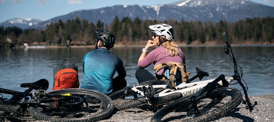 Zwei Radfahrer am See mit Specialized E-Bikes vor Bergkulisse