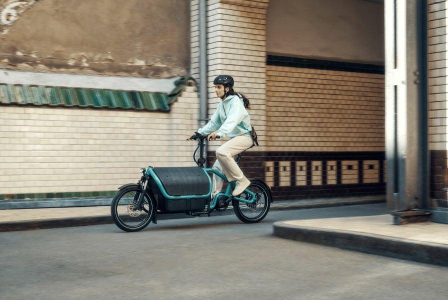 Frau auf Riese & Müller Lastenrad in urbaner Umgebung bei Eurobike 2024