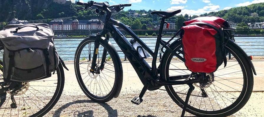 Specialized Vado 5.0 E-Bike mit Gepäcktaschen vor Flusslandschaft