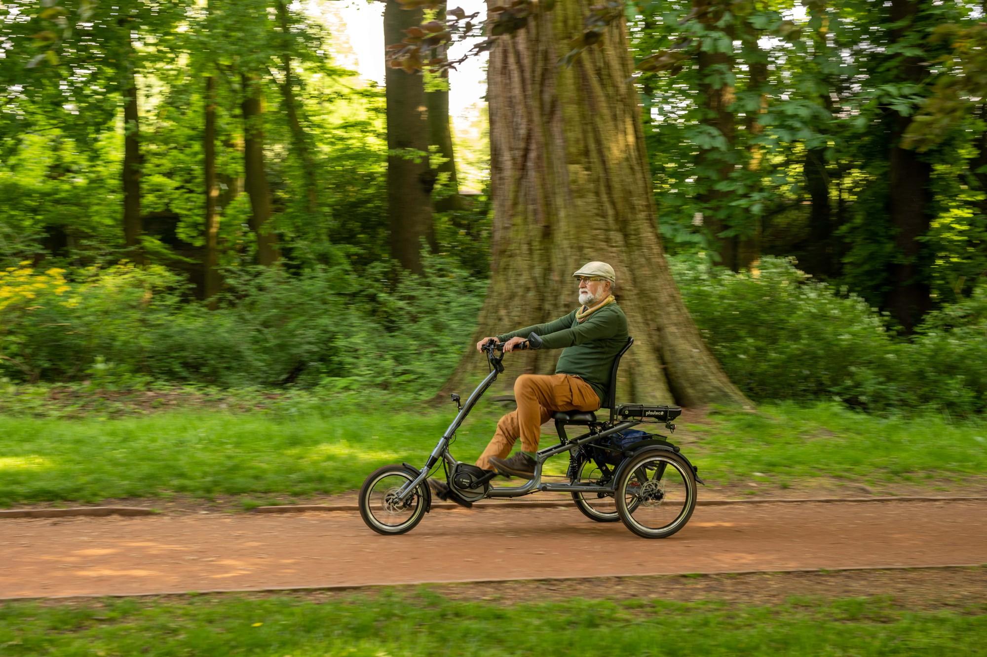 Das Bild zeigt einen älteren Mann, der auf einem E-Bike von Pfautec fährt