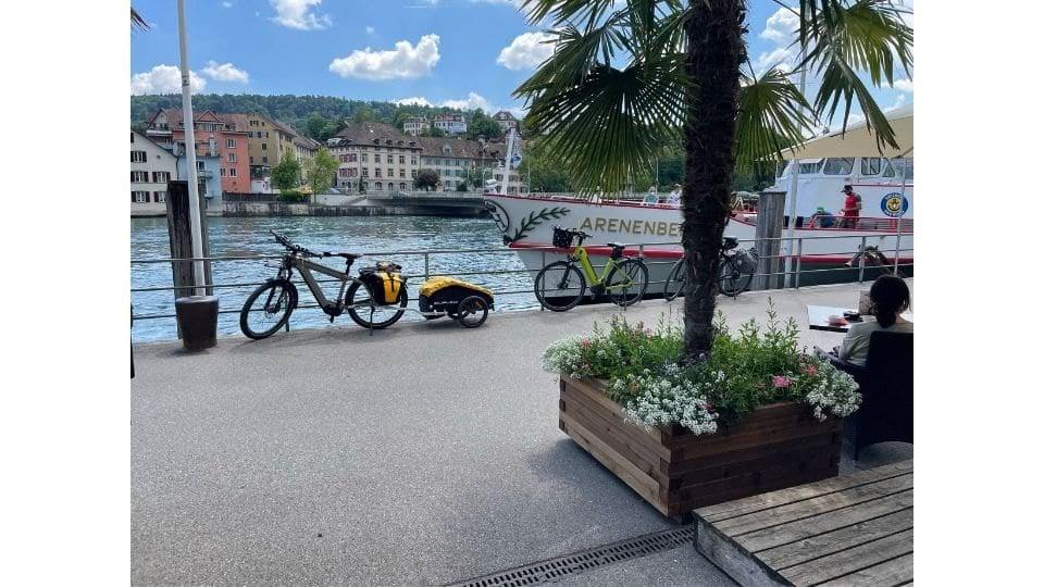 Zwei Fahrräder mit Anhänger an der Uferpromenade bei Sonnenschein