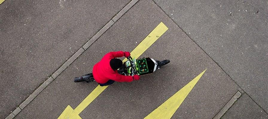 Luftaufnahme eines Packster E-Bikes mit Getränkekiste auf Asphalt