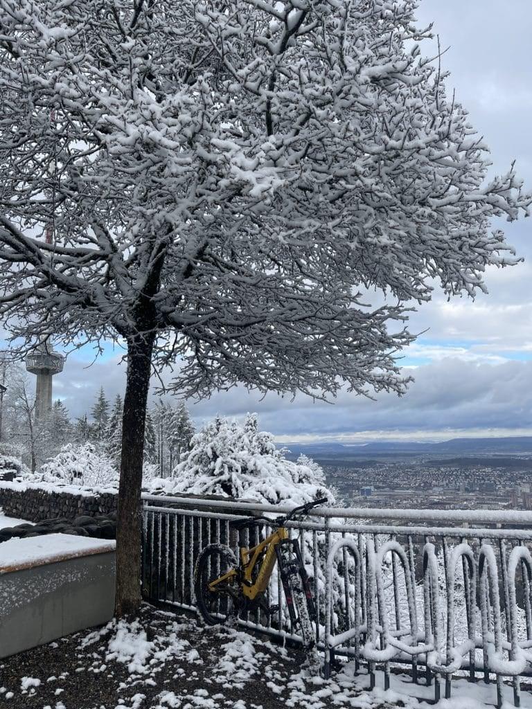 Verschneites E-Bike vor Aussichtspunkt mit Winterlandschaft