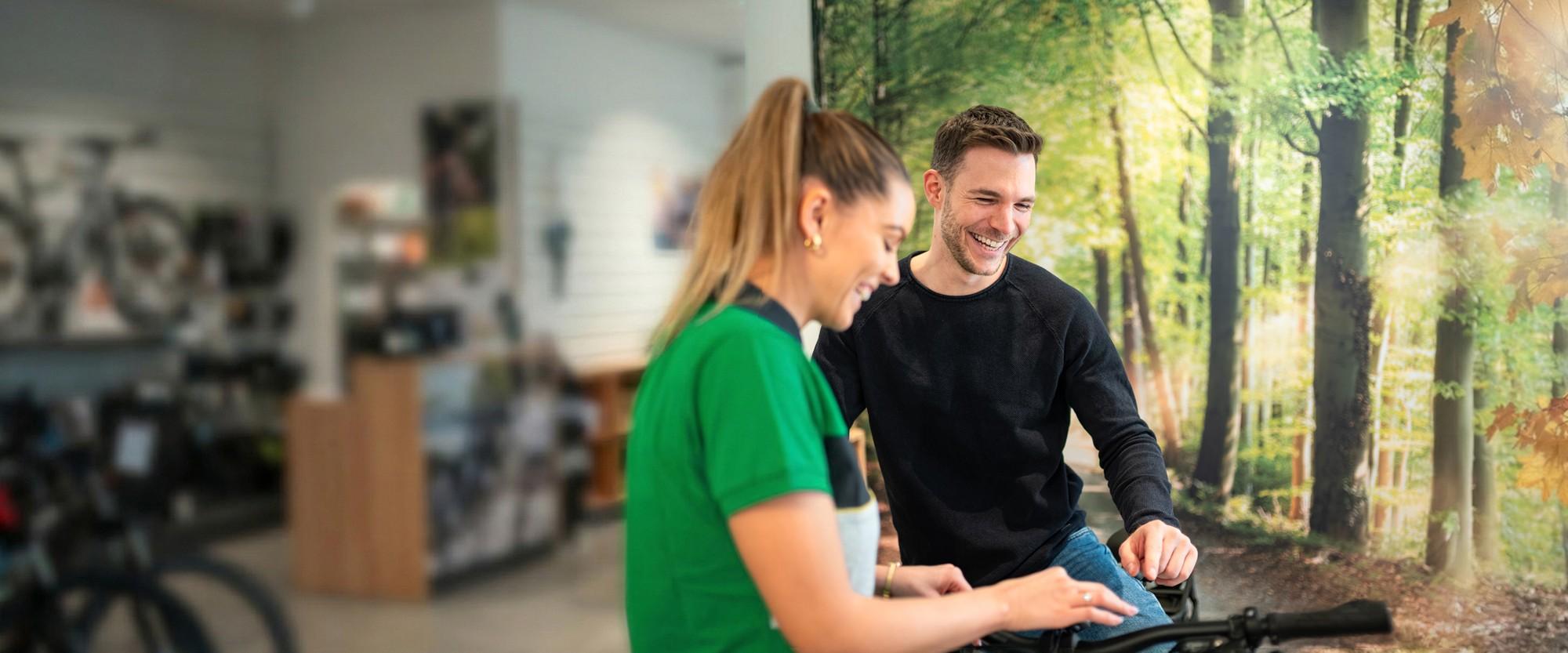 Eine e-motion Mitarbeiterin informiert einen interessierten Kunden über e-Bikes
