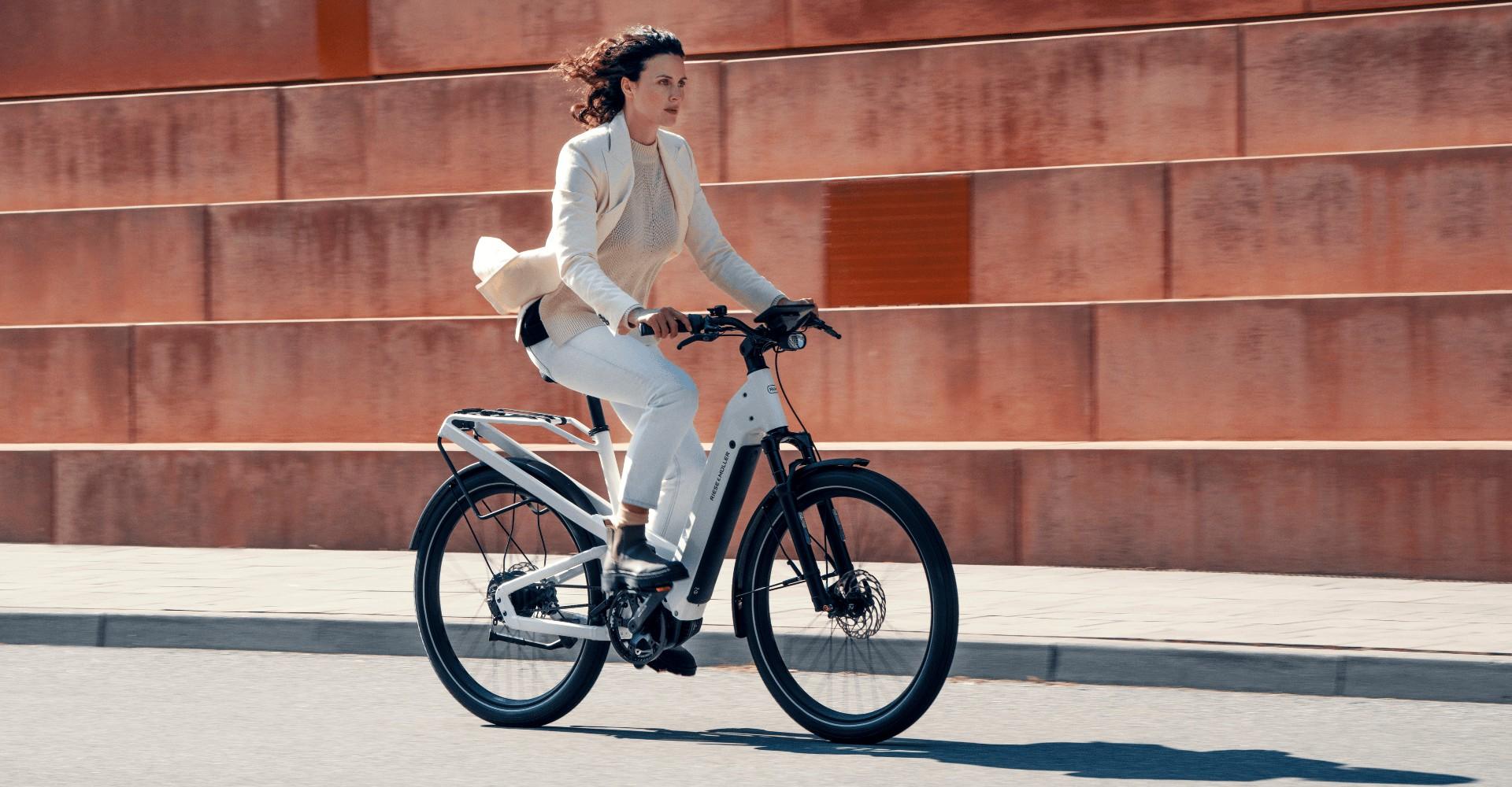 Eine Frau fährt mit Riese & Müller Homage e-Bike in urbaner Umgebung