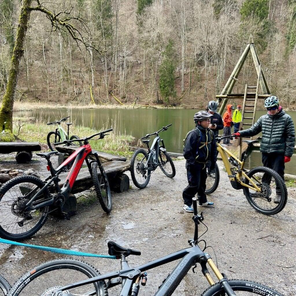 Gruppe von Radfahrern mit E-Bikes an einem Waldsee