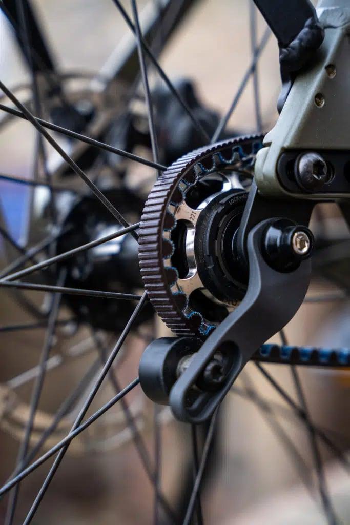Nahaufnahme eines Fahrradriemenantriebs mit Nabe und Speichen