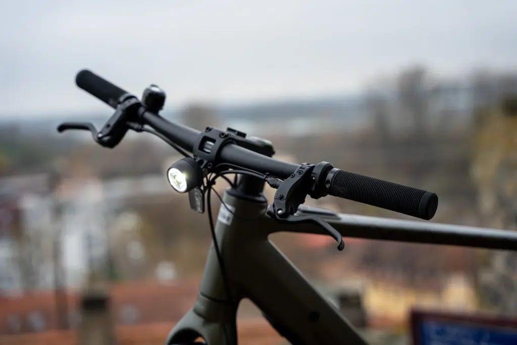 Nahaufnahme eines Fahrradlenkers mit Licht und Bremshebeln