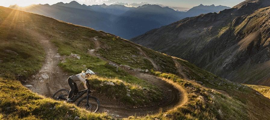 Mountainbiker auf Specialized Levo SL auf alpinem Trail bei Sonnenuntergang