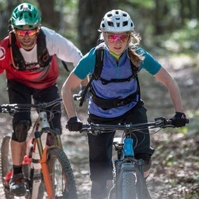 Zwei Mountainbiker auf Waldpfad mit Schutzkleidung