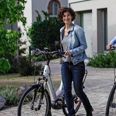 Zwei Personen schieben E-Bikes in urbaner Umgebung
