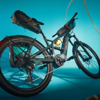 E-Mountainbike mit Zubehör vor blauem Hintergrund