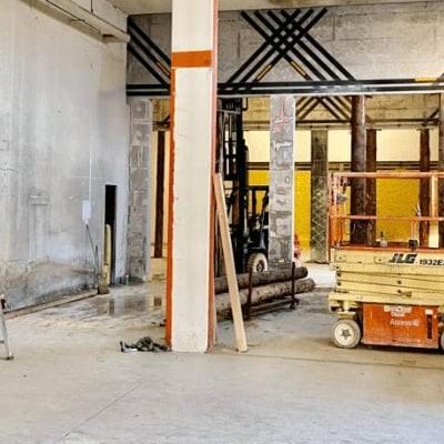 Industriehalle mit Hebebühne und Leiter in Bauumgebung