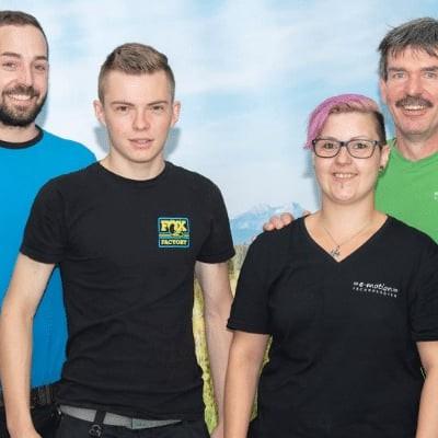 Gruppe von Menschen in bunter Kleidung vor Landschaftshintergrund