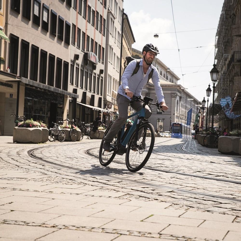 Bosch e-Bike, Mann fährt über Gleise in der Stadt