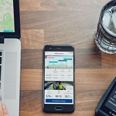 Laptop, Smartphone mit eBike-App und Bosch eBike-Display auf Holztisch