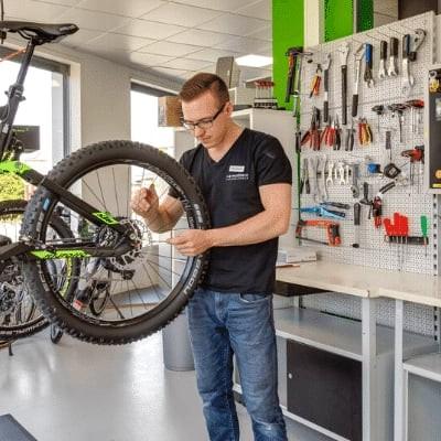 Fahrradmechaniker bei der Arbeit in moderner Werkstatt