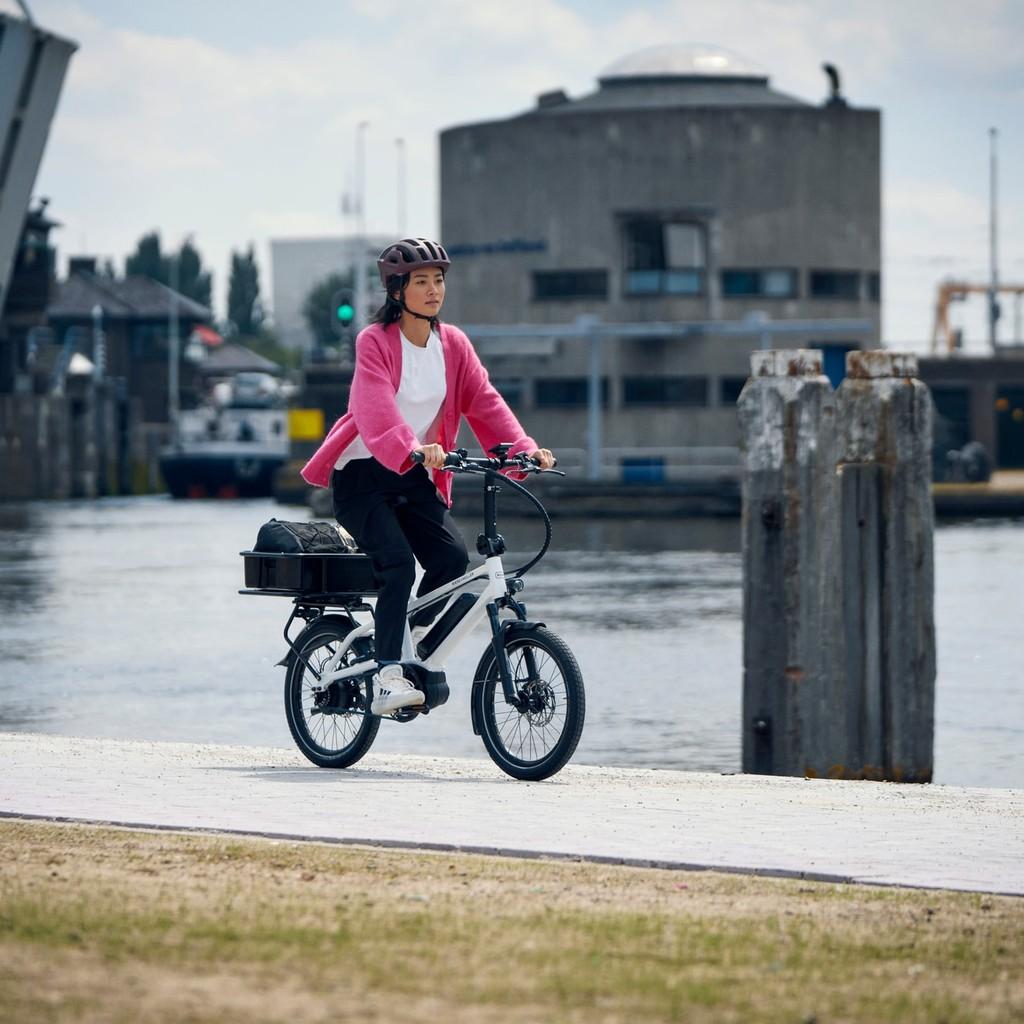 Entdecken Sie das Tinker 2023 E-Bike in Aktion. Perfekt für urbane Mobilität und stilvolles Fahren entlang malerisc