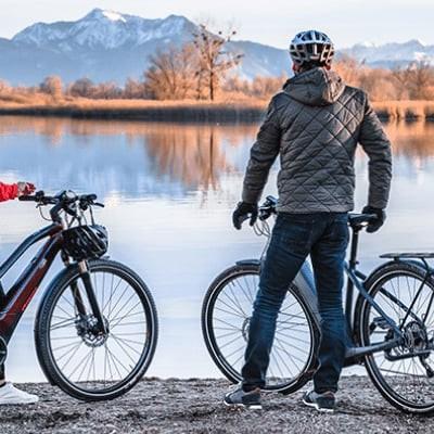Zwei Personen mit E-Bikes vor malerischer Bergkulisse