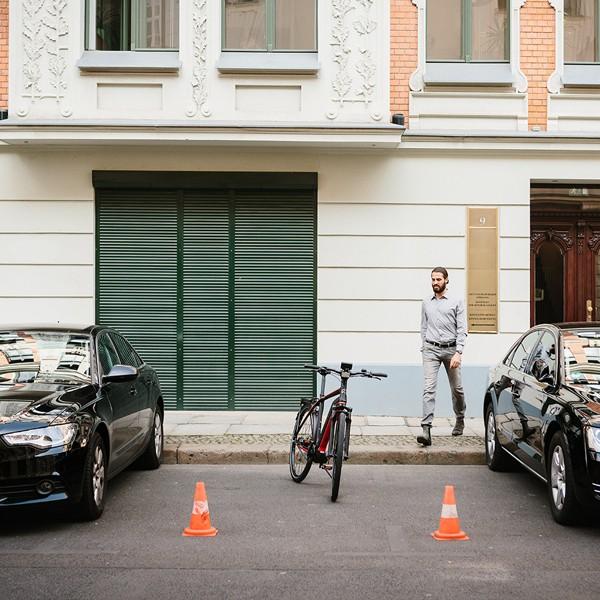 Ein Kalkhoff E-Bike ist zwischen zwei Audi Autos geparkt. Ideal für urbane Mobilität und nachhaltiges Pendeln in de
