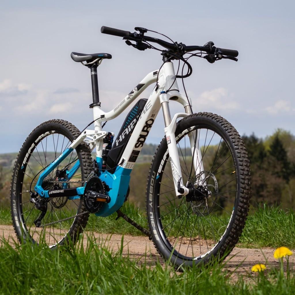E-Bike auf einem Feldweg mit grüner Landschaft im Hintergrund