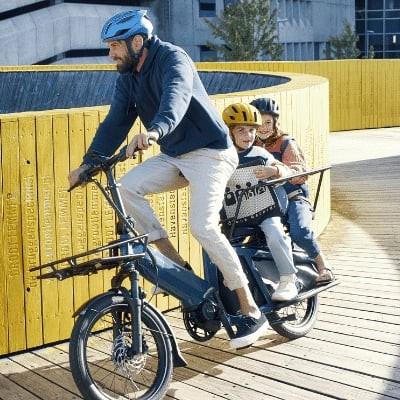 Riese & Müller Multitinker E-Bike mit zwei Personen auf Holzweg