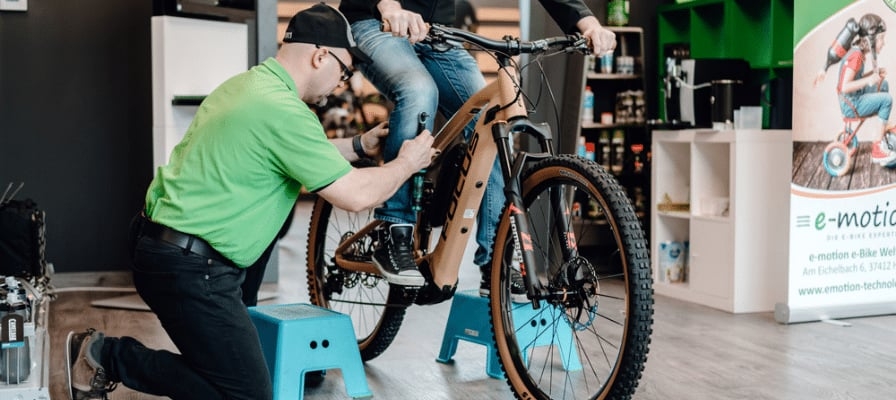 Mann justiert E-Mountainbike in Fahrradgeschäft