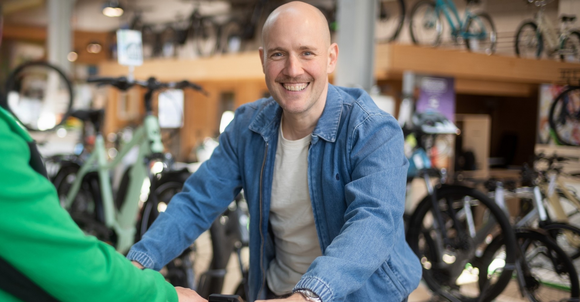 Beratung Oli.P sitzt lächelnd auf einem e-Bike