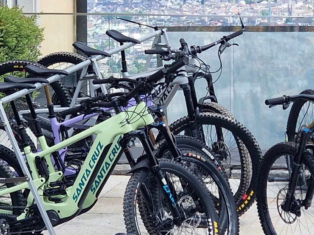 Mehrere Santa Cruz E-Bikes auf einer Terrasse mit Stadtblick