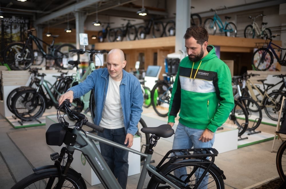 Zwei Männer betrachten ein E-Bike in einem Fahrradgeschäft