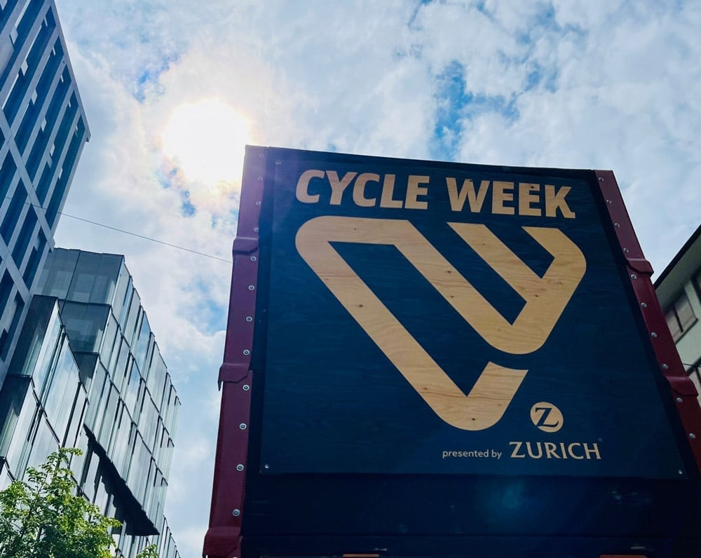 Cycle Week Plakat in Zürich mit modernem Gebäude im Hintergrund