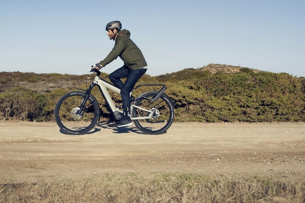 Mann fährt Riese & Müller Superdelite E-Bike auf unbefestigtem Weg