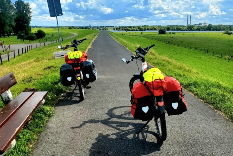 Zwei beladene Fahrräder auf einem Radweg in ländlicher Umgebung