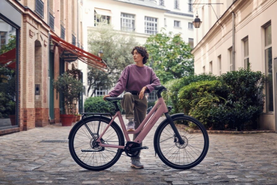 Frau mit Riese & Müller E-Bike in urbaner Umgebung
