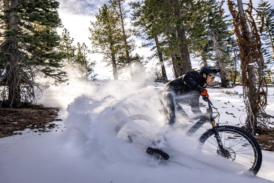 Mountainbiker fährt durch Schnee im Wald