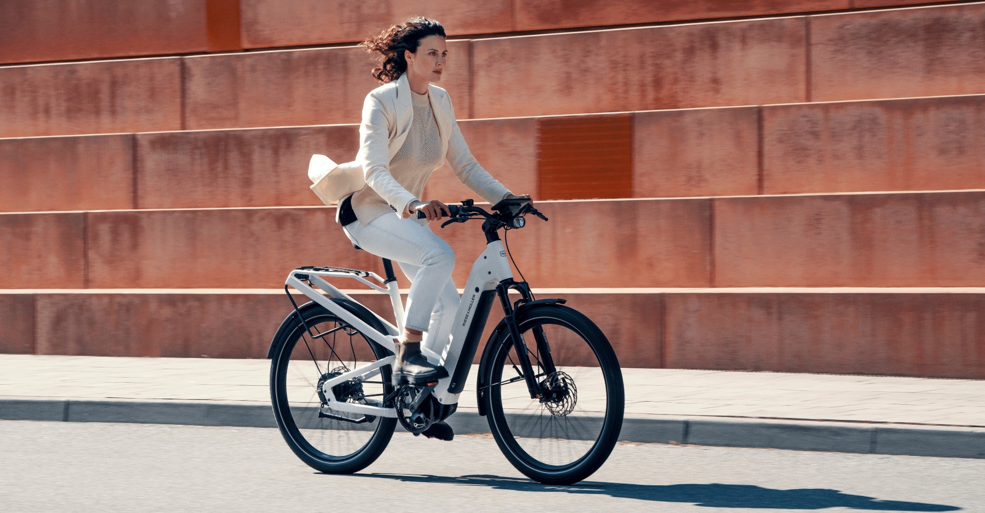 Eine Frau fährt mit Riese & Müller Homage e-Bike in urbaner Umgebung