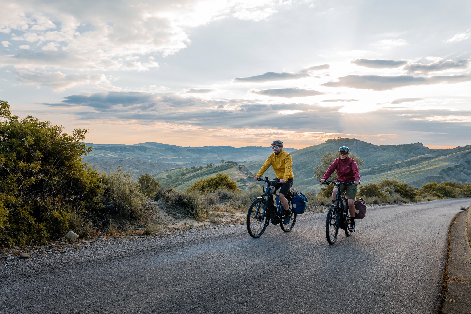 Zwei Personen fahren auf e-Bikes mit Bosch PX Antrieb durch malerische Kulissen